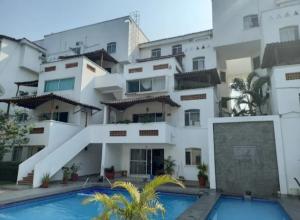 a large building with a swimming pool in front of it at Condominio BrisaSol in Manzanillo