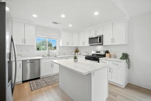 una cucina bianca con mobili bianchi e un forno a microonde di Sunny Desert Retreat Near Coachella & Stagecoach home a Desert Groves Mobile Home Park