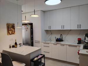a kitchen with white cabinets and a refrigerator at Rony's Place in Ashkelon