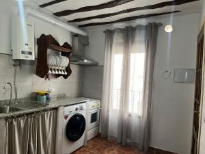 a kitchen with a sink and a washing machine at Apartamento rural La Sabina in Zújar