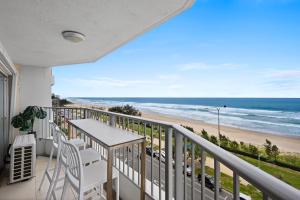 een balkon met een tafel en stoelen en het strand bij Pacific Plaza Apartments in Gold Coast