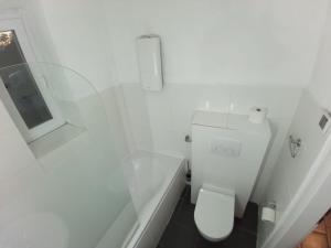 a white bathroom with a toilet and a window at Zimmer am Hauptbahnhof 1 in Minden