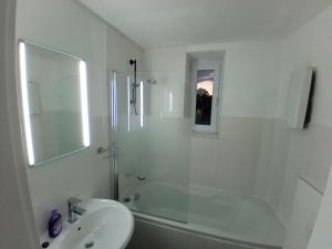 a white bathroom with a shower and a sink at Zimmer am Hauptbahnhof 1 in Minden