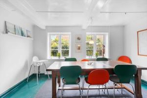 a dining room with a wooden table and green chairs at AE243-Marstal-Strandstraede-15 in Marstal
