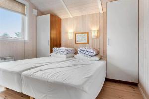 a bedroom with a large white bed with two pillows at M12018-Vaeggerlose-Baeverstien-11 in Marielyst +18 photos