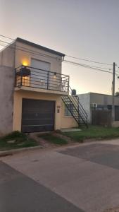 a house with a garage with a balcony on it at Departamento turístico CA in Gualeguaychú