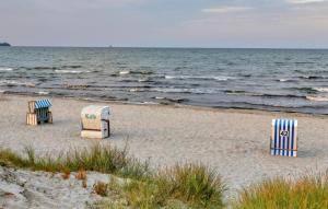 three chairs and chairs on a beach near the water at Amazing Apartment In Altenkirchen in Altenkirchen +39 photos