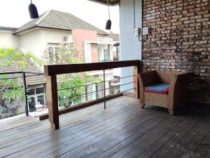 a balcony with a chair on a wooden deck at Kirana rooms in Kerobokan