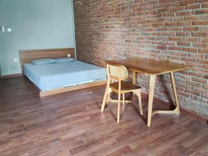 a room with a table and a bed and a brick wall at Kirana rooms in Kerobokan