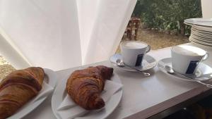 two croissants and two cups of coffee on a table at Sa Teria Village - Camere Deluxe - in Tertenìa