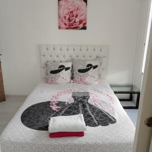 een slaapkamer met een bed met een zwart-witte sprei bij Maison agreable in Blois