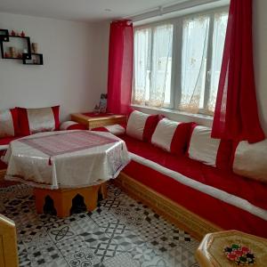 een woonkamer met een rode en witte bank en een raam bij Maison agreable in Blois