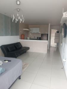 a living room with a bed and a kitchen at loft barbudo in Araruama