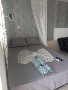 a bed with a blanket on it with aimeter at loft barbudo in Araruama