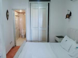 a bedroom with a white bed and a bathroom at 321or322 the finest Porto Marina Chalets Tower 3 in El Alamein +51 photos