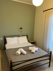a bedroom with a bed with two towels on it at Kanarinia Guesthouse in Kala Nera