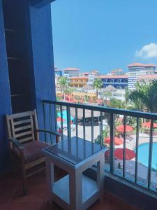 a table and a chair on a balcony with a pool at 321or322 the finest Porto Marina Chalets Tower 3 in El Alamein