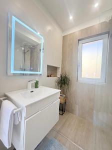 a bathroom with a white sink and a window at Modern Apartment in City Center in Iaşi