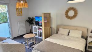 a bedroom with a bed and a tv and a table at Studio Leman Ciel avec parking privé gratuit in Gex