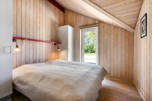 a bedroom with a large bed and a window at C11711-Hemmet-Strandvaenget-39 in Falen