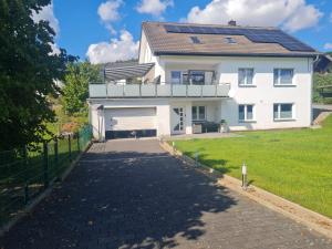 a white house with solar panels on the roof at Ferienwohnung Am Meisenberg in Marsberg