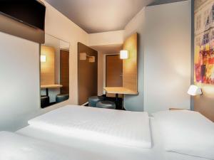 ビーレフェルトにあるB&B Hotel Bielefeld-Ostのベッドルーム1室(ベッド2台、鏡2つ付)