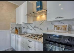 a kitchen with white cabinets and a stove top oven at Vila Didi in Fažana