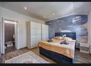 a bedroom with a large bed and a painting on the wall at Vila Didi in Fažana