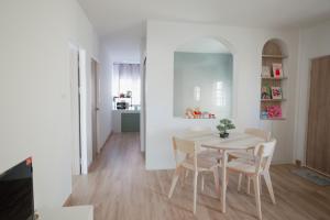 a white dining room with a table and chairs at Be House 5 SongKhla in Songkhla