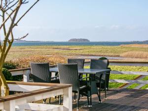 a table and chairs on a deck with a view of a field at Secluded Retreat by Water - By Traum Ferienwohnungen in Bøjden