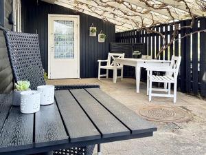 ein Holztisch und Stühle auf einer Terrasse mit einem Tisch und einem weißen Tisch in der Unterkunft Secluded Retreat by Water - By Traum Ferienwohnungen in Bøjden