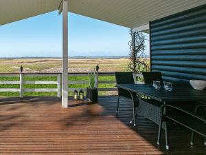eine Terrasse mit Tisch und Stühlen auf einem Deck in der Unterkunft Secluded Retreat by Water - By Traum Ferienwohnungen in Bøjden
