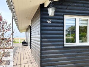 a house with a black wall and a window at Secluded Retreat by Water - By Traum Ferienwohnungen in Bøjden