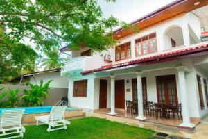 a house with a lawn in front of it at Villa Comfort in Hikkaduwa
