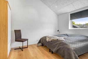 una camera da letto con un letto e una sedia di C11642-Bork-Nordmarken-3 a Falen