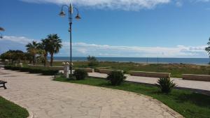a walkway next to the beach with a street light at Casa Paola - A due passi dal mare in Pozzallo