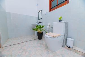 a white bathroom with a toilet and a sink at Villa Comfort in Hikkaduwa +22 photos