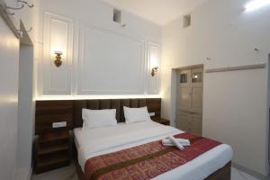 a bedroom with a bed with two white towels on it at Bhawani Homes in Varanasi