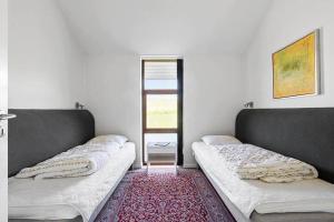 two beds in a room with a red rug at SB125-Egernsund-Marinavej-28 in Rendbjerg