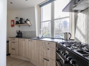 a kitchen with a stove top oven next to a window at Renovated luxury water tower within walking distance of the beach boulevard in Vlissingen
