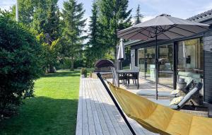 a patio with an umbrella and a table and chairs at Cozy Home In Dronningmølle With Sauna in Dronningmølle +22 photos