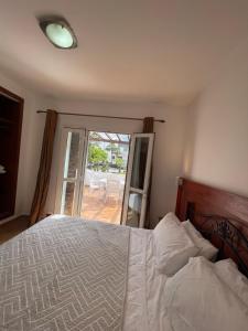 a bedroom with a bed and a door to a patio at Les Étoiles du désert in Cabo Negro