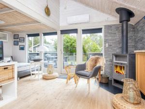 a living room with a fireplace and a table and chairs at 5 person holiday home in Hovborg in Hovborg