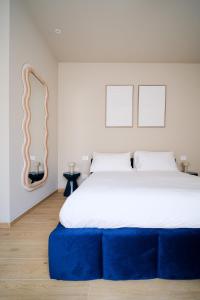 a bedroom with a large bed with a blue ottoman at Premier Stay The Garden - Bernina Experience in Tirano