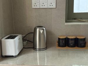 a kitchen counter with a coffee maker and a toaster at The Cottage Kandy in Kandy