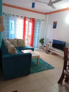a living room with a blue couch and a tv at Mtwapa Luxury Residence Block 1B in Mombasa