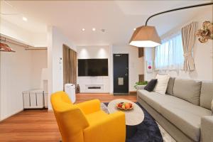 a living room with a couch and a table at Tomo House 四谷三丁目 301 in Tokyo