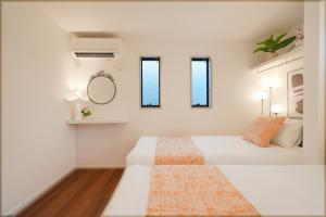 a bedroom with two beds and a mirror at Tomo House 四谷三丁目 301 in Tokyo