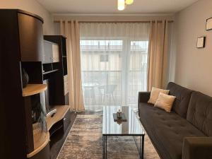a living room with a couch and a glass table at Modern apartment with balcony in Užliedžiai