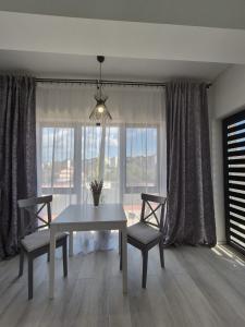 a dining room with a table and two chairs and a window at Antiaeriana Sunhouse in Bucharest